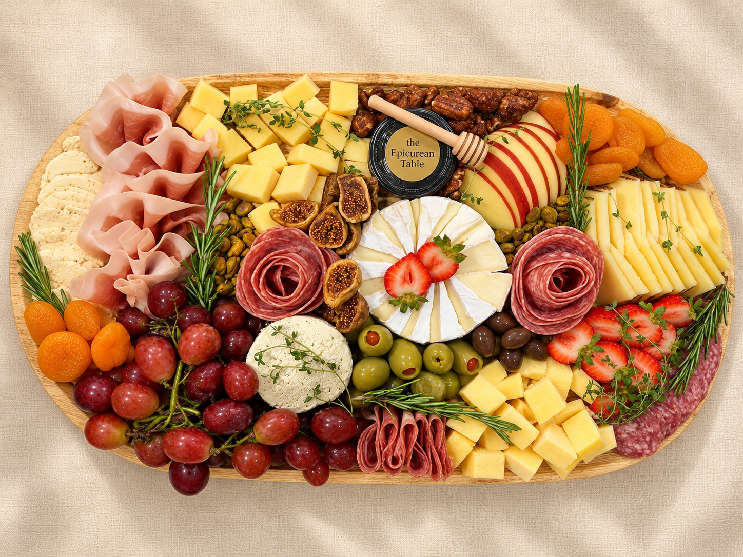 The Epicurean Table board with salami roses, cheeses, fruit, olives, and honey